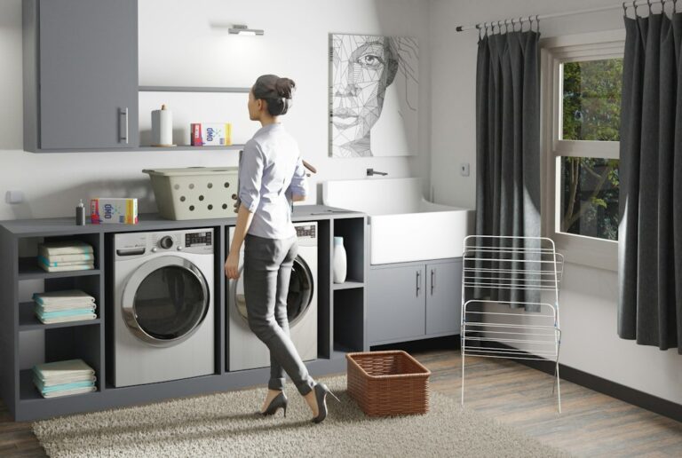A homeowner cleans a refrigerator seal while checking nearby appliance connections in a bright kitchen.